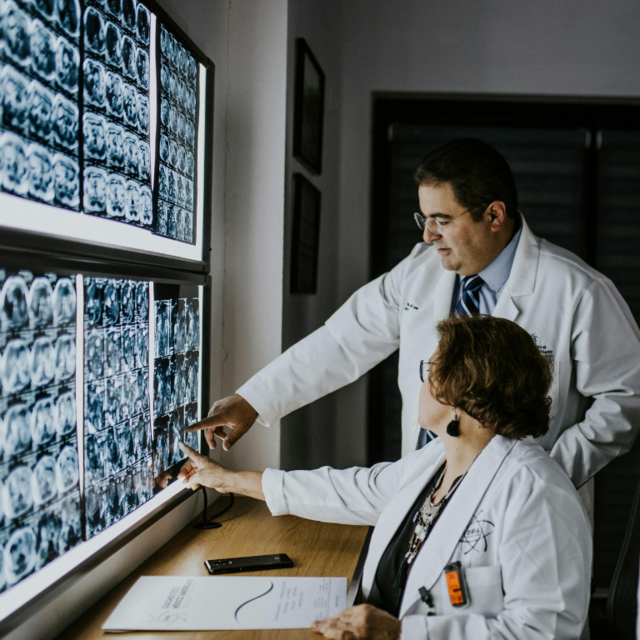 Two doctors reviewing brain scans